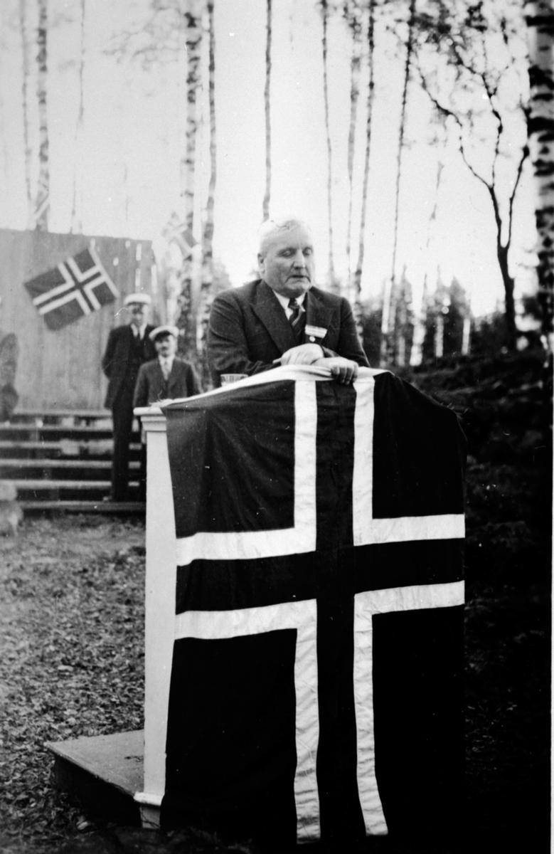 Disponent ved Moelven Brug, Severin Myrbakken på talerstol med flagg, 17 maitaler, Moelv.