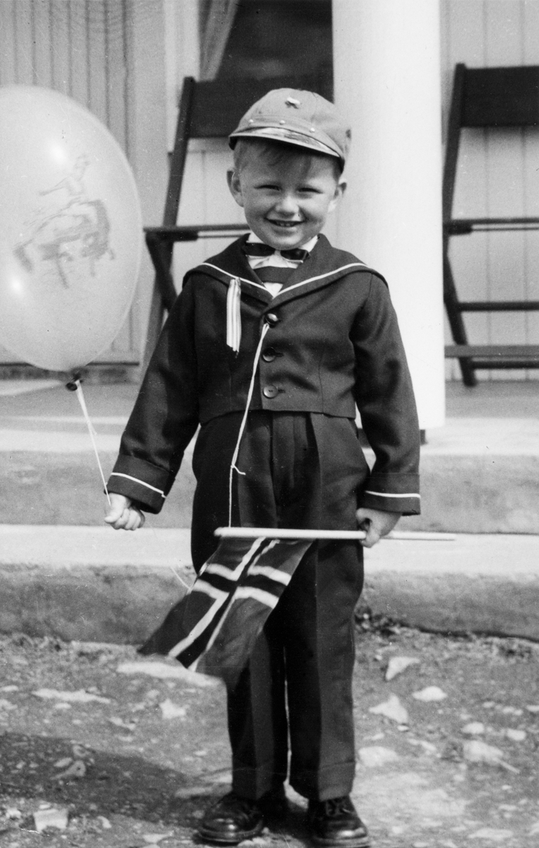 Portrett, Hans Chr Medlien (5) med ballong, flagg og nypusse sko på 17. mai feiring i Næroset, Ringsaker i 1960.