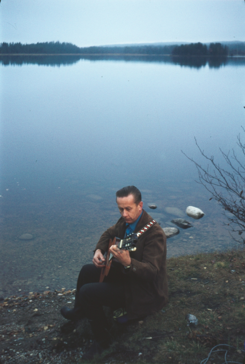 Vidar Sandbeck med gitar i vannkanten