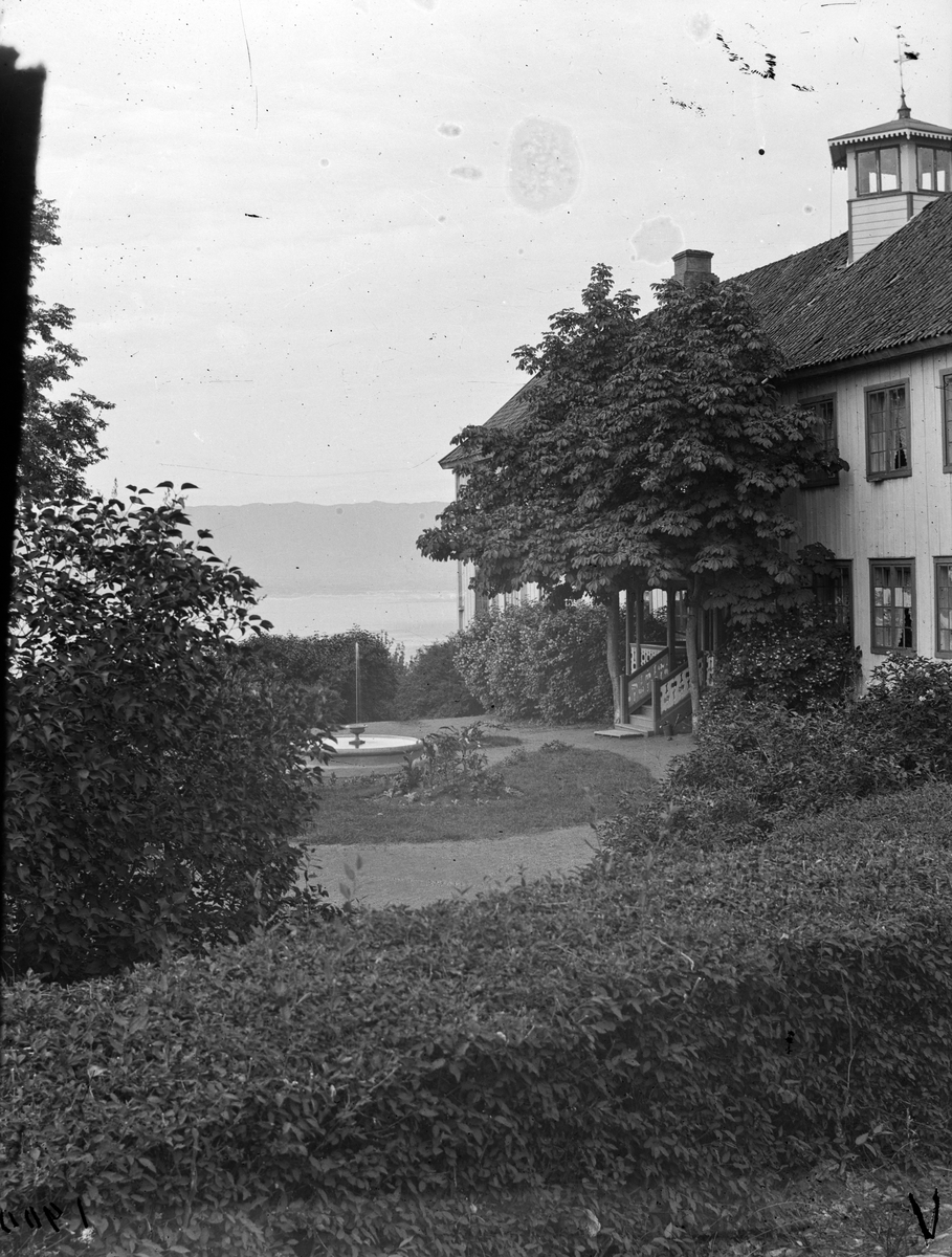 Hovinsholm gård, Helgøya i Ringsaker. Hagen og hovedbygningen med tårn sett fra flaggstangplassen. Foto Jacob Hoel 1900.