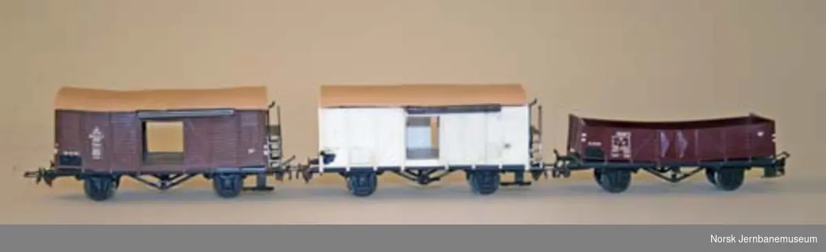 Modelltogsett med dieselmotorvogn, tre godsvogner, personvogn, skinner og transformator