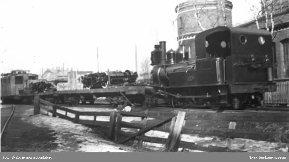 Elektrisk lokomotiv til Rjukanbanen under transport fra Skabo, trukket av et smalsporet damplokomotiv av type IV
