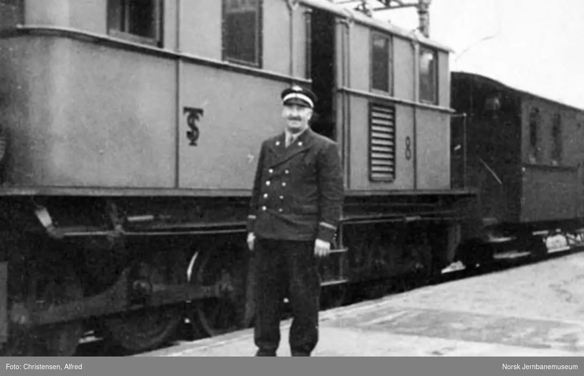 Lokomotivfører Peder M. Berg ved siden av Thamshavnbanens elektriske lokomotiv nr. 8