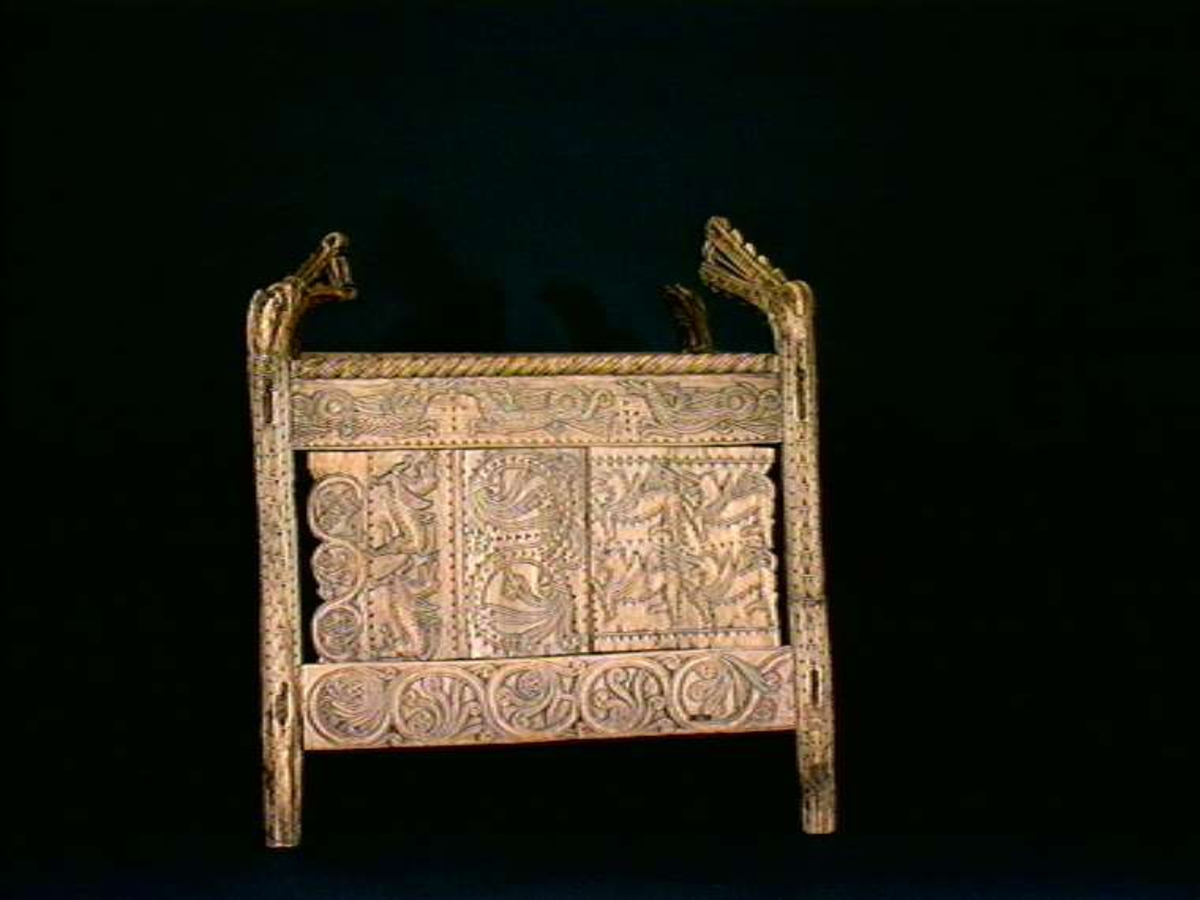 Fire søyler med skåret dyrehode-ornamentikk, sammenføyet med tverrbord og fyllinger. Bunn er åpen foruten to tverrstaver. Hele utsiden er rikt dekorert med utskåret dyr og ranker.