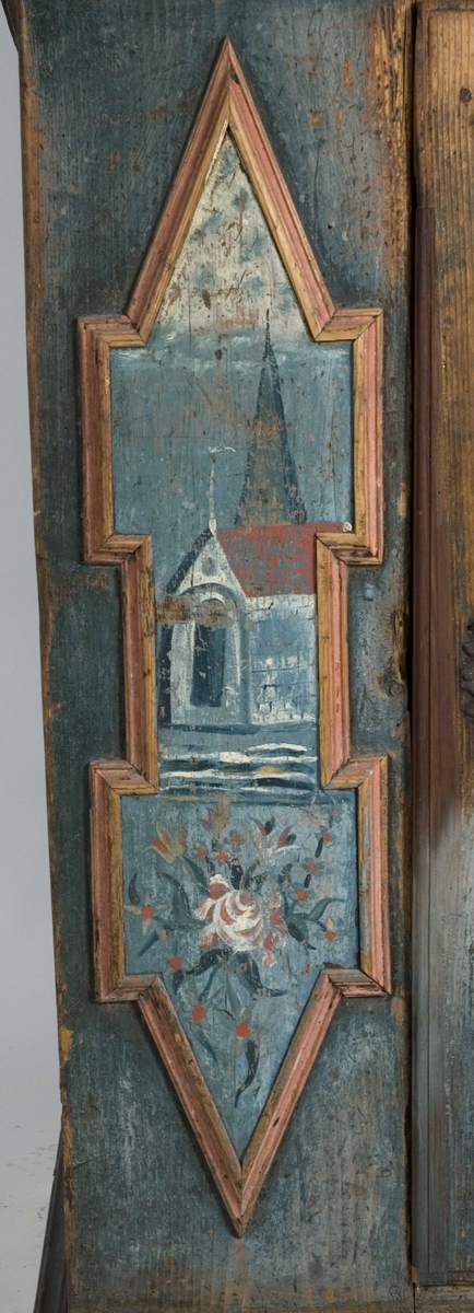 Skap, framskap i en del, to dører oppe og nede. Bibelske motiver; Moses og de ti bud. Gud på en sky, en brennede sky eller busk, en mann som har mistet en sko og en stokk.