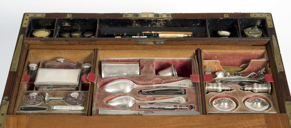Skrin med skriveskive i lokket, skuffer på kortsidene og en mengde skjulte rom. Rommene innehoder gjenstander for bruk ved reiser: Barberutstyr; måleinstrument; bestikk; hygieneartikler; røykeutstyr; fiskeutstyr; duelllpistoler med mer.