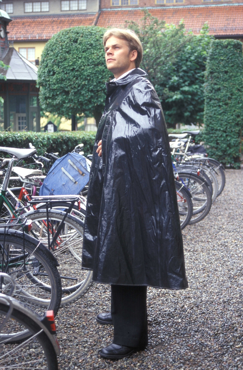 Regntøy, mann i sort regnslag, ved sykler