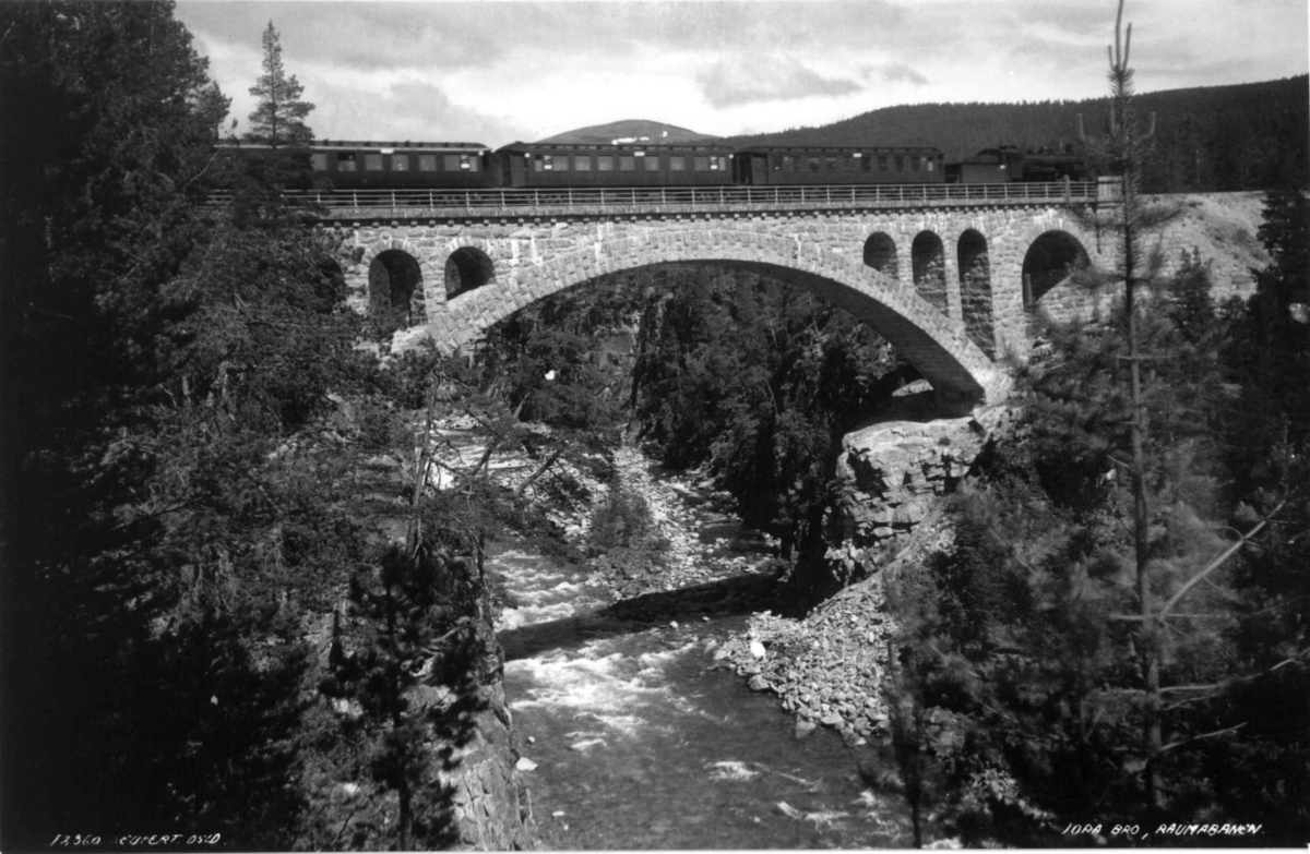 Raumabanen, Jora bro, Dombås, Dovre, Oppland 1935. Tog passerer broen. Elv. Skog.