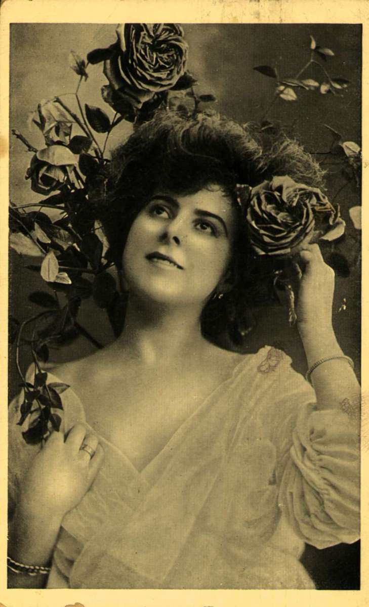 Postkort, Nyttårshilsen. Fotografi i svart/hvitt. Kvinneportrett. Håret er oppsatt og pyntet med roser.
