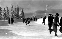 Tryvann skøytebane, Oslo. 1936. Skøyteløpere i sving på isen