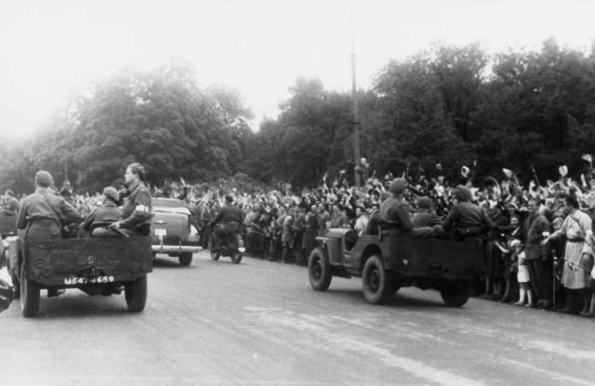 Fra Oslo 7. juni 1945.
Kongen kommer tilbake.Kongens bil, AI, og andre biler på vei opp mot slottet.