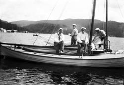 Fire menn ombord i en seilbåt. Fotografert sommeren 1924.