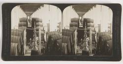 Stereoskopi. Menn drikker vin på bodega. Vintønner langs veg