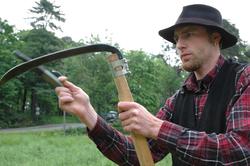 Fra slåttonna i juni 2005.Vert i drakt, sliper ljåen.