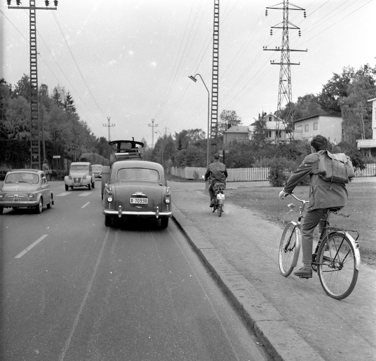 Biler, sykkel og moped kjører på veien i Ullernåsen, Oslo. Fotografert 8. oktober 1959.