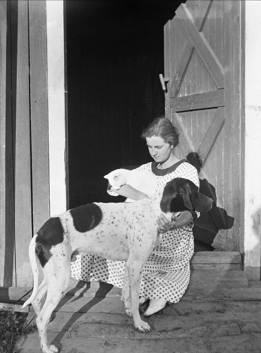 Dordi Arentz med hunden Wapi og katten fotografert i juni 1925.