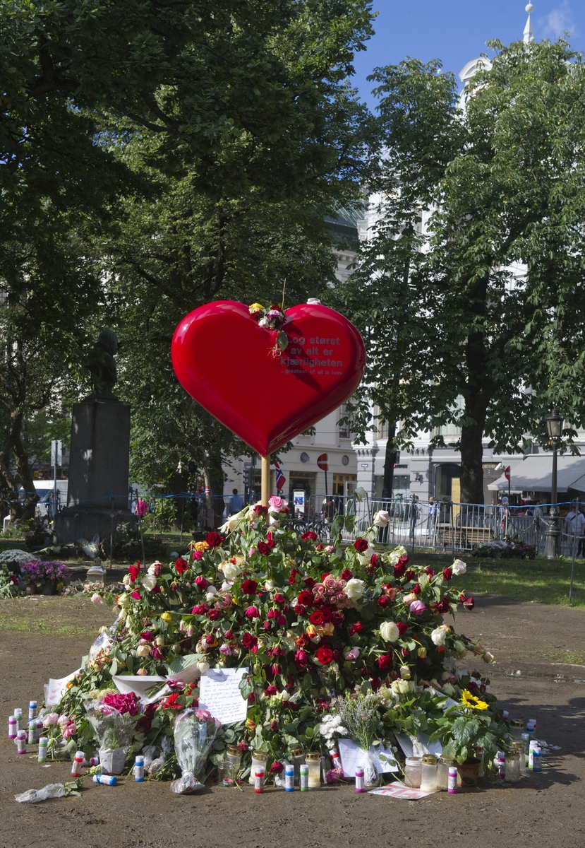 "Sorg i det offentlige rom". Et stort hjerte med påskriften "Og størst av alt er kjærligheten" omkranset av blomster, lys, hilsener og flagg ved Oslo Domkirke 22.08.2011, en måned etter terrorhandlingene i Oslo og på Utøya.