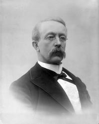 Portrett, mann med bart og briller. Herr Murud(? )Larsen.