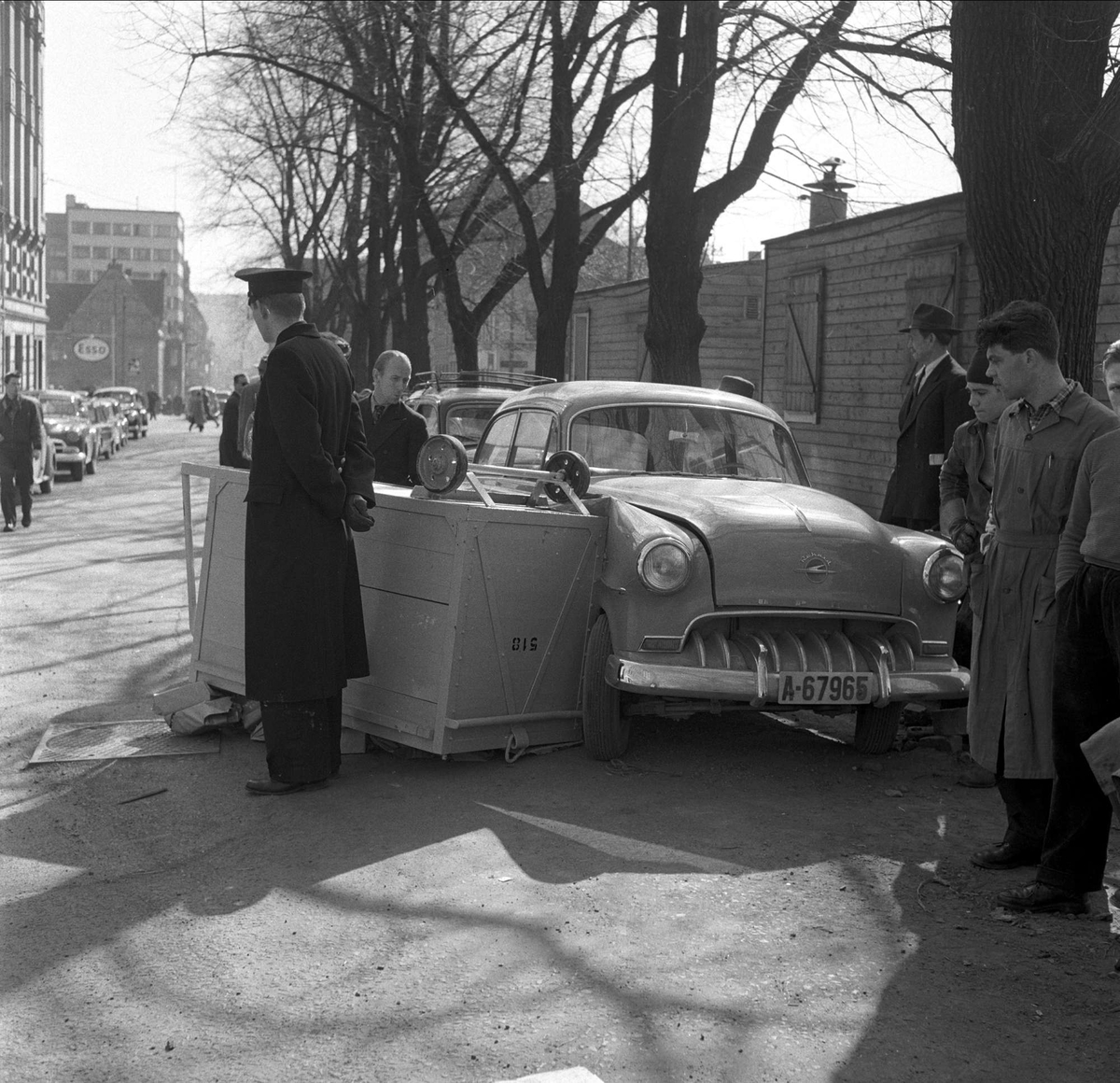 Kasse som har veltet over bil, noen tilskuere og en politimann. Fredag 13. april 1956, Oslo.
