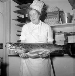 Kvinne viser frem fangsten etter fiske i Mjøsa, 
30.12.1956