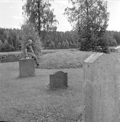 Skjeberg, Østfold. Fortidsminner. Mann på kirkegård med grav