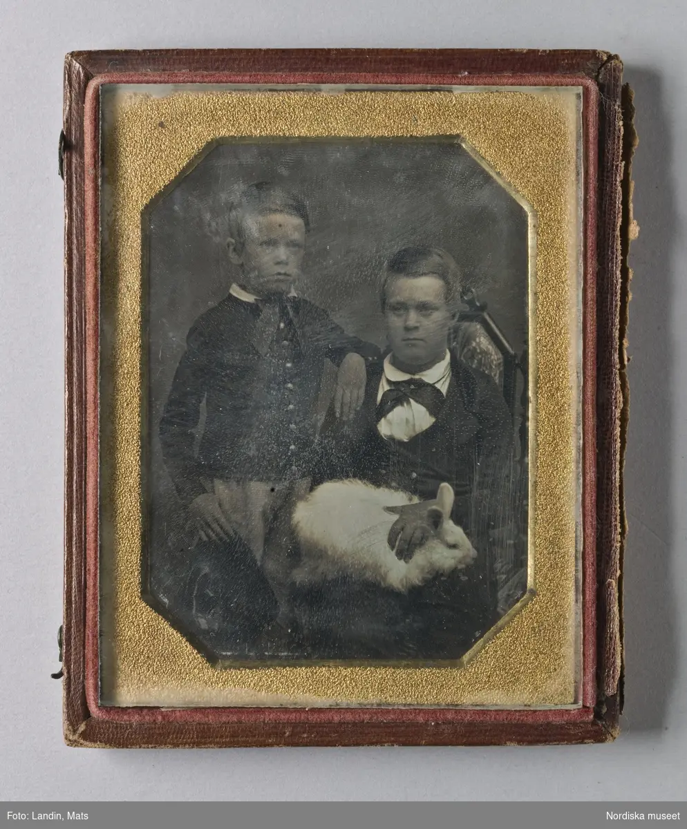 Två pojkar, stående resp. sittande med en kanin i knäet.  Dagerrotyp / daguerreotyp i etui utan lock.
Nordiska museet inv.nr 205459
-
Portrait of two young boys and a rabbit. Quarter-plate daguerreotype.