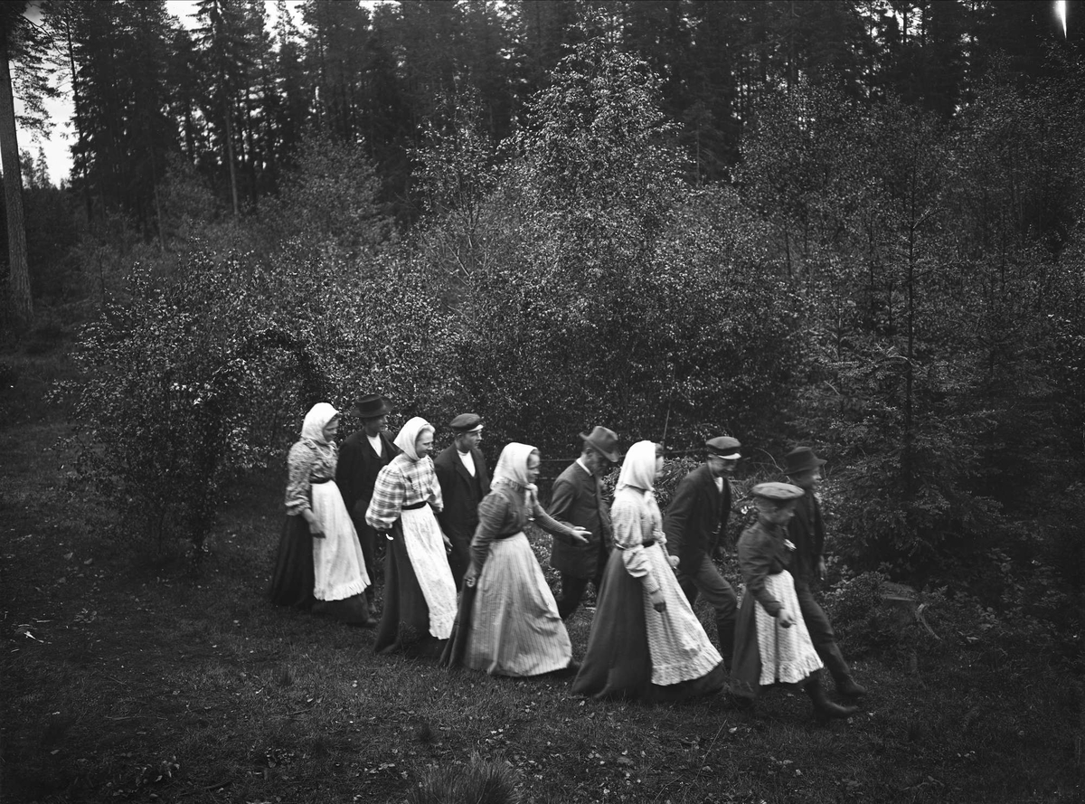 Traditioner. Trefaldighetsafton. Nils Edvard Hammarstedt vandrar med bygdens ungdom ut till en gammal källa trefaldighetsafton 1908 i Lövmarken, Söderbärke, Dalarna.