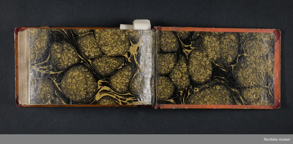 "Röda boken". Liten bok med initialerna H B på framsidan och årtalet 1728 på baksidan. Boken innehåller skisser av myter, människor, djur, byggnader och växter. Enligt medföljande utdrag ur brev från Knut Almström till direktör Fredrik Wehtje 1952 så har boken tillhört Petter Gustaf Löfström och därefter en man med efternamnet Bundred som var gravör vid Rörstrand.
