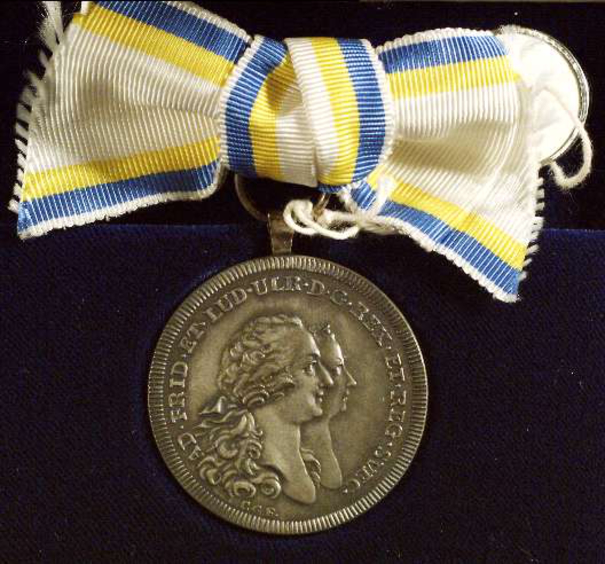 Framsidan av medaljen med Adolf Fredrik och Lovisa Ulrikas bilder i profil.