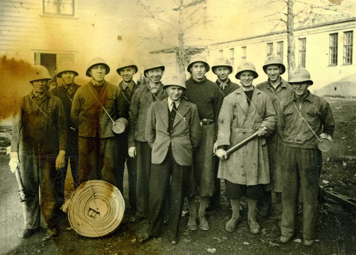 Bedriftsbrannvern ved Andfossen Bruk, gruppe med 11 menn med hjelmer og brannslange. 
