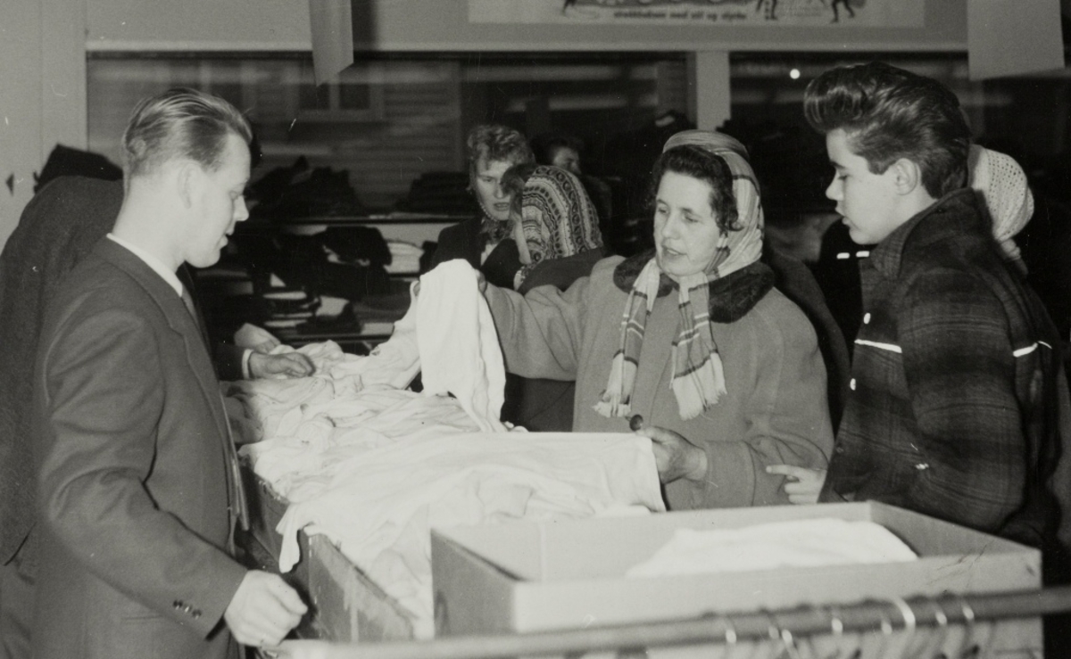 Gottvald Eikeskog ekspederer kunder i herrundertøysavdelingen i konfeksjonsbutikken til Jonas Øglænd Sandnes under vårsalget 1960.