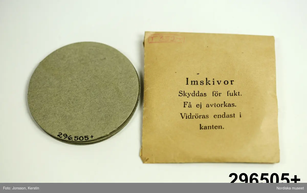 Huvudliggare:
"GASMASK, tyg, metall; förvaras i fodral av hårdpressad papp; se bilaga. Mått fodral Br 19 cm, Tj 12,5 cm, H 25,8 cm.
G från museets skyddsrum, 1939. /1973/ 8/8 Nordiska museet, Stockholm."

Bilaga [kopia av katalogkort]:
"Skyddsmask, storlek 3, i två delar. Ansiktsskydd av kraftigt grått tyg med fastsättningsband av tyg och resår. Skinnskodd kant.
Två syngluggar (diam 8,5 cm) med metallkant och glas. På insidan imskydd av celluloid, fäst med en avtagbar metallfjäder. Imskydden är utbytbara.
Framför näsa och mun ett äggformat metallstycke med två gängade hål. I 'munhålet' sitter ett runt metallstycke (diam 6 cm, h 1 cm) med hål längs ytterkanten. I munstycket sitter ett gummimembran, som ger efter vid utandning. Runt den plana sidans kant står inpressat 'STOCKHOLM BIRGER CARLSON & Co. A.B. 'BICAPA' '. Läderpackning avslutar det gängade partiet. I inandningshålet ligger en gummipackning. Här ska en grå metallbehållare fastskruvas, vilken i sin yttre del är försedd med ett skyddspapper på vilket står: 'Detta papper avlägsnas vid krigsutbrott eller då behållaren ska användas för övning'.  Den gängade delen är skyddad av en kapsyl. På behållaren är stämplat ''1939' B13341E' samt tre kronor. På ena sidan sitter ett blått varu-märke. I fodralet finns också en förpackning stämplat av samme tillv och med årtalet 1939. På förp står 'Imskivor / skyddas för fukt. Får ej avtorkas. Vidröras endast i kanten.' Alltsammans ligger i en grå oval kartong av hårdpressad kartong. På locket är tillverkarens namn inpressat och strax nedanför locket står på ena sidan på en silverfärgad etikett 'FÖR AKTIVT LUFTSKYDD / SVENSK TILLVERKNING'. Runt kartongen (fodralet) sitter tygband, så att skyddsmasken kan bäras över axeln.
1973-08-08 Fynd i Nordiska museet
1976-02-27 BR"