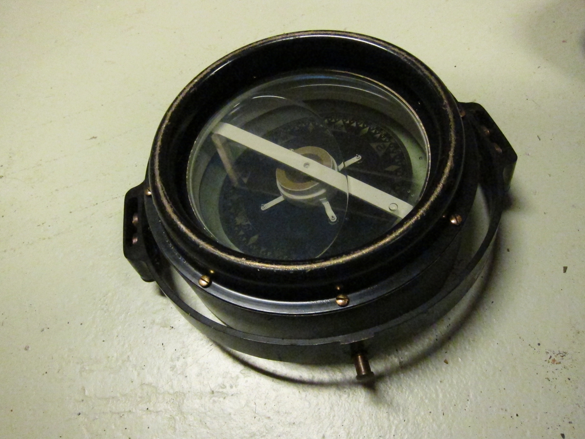 Sortlakkert kompass som kan betraktes fra begge sider.