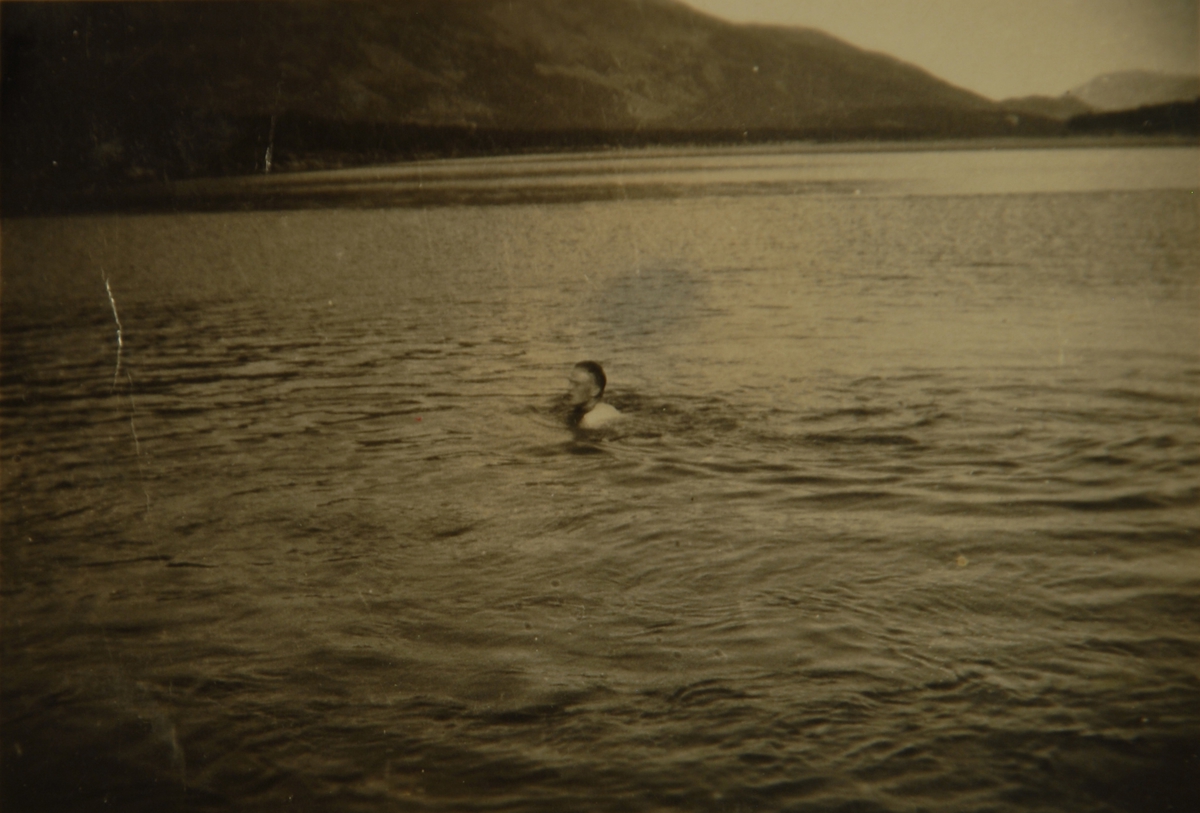 Mann bader i fjord eller vann