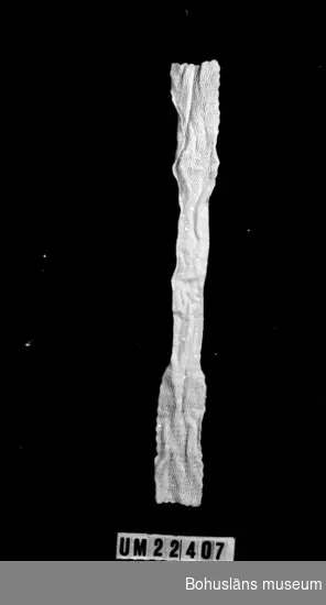 594 Landskap BOHUSLÄN

Dubbelstickad vit halsduk i vågformad ribbstickning vid varje ände, 
c:a 2/3 av halsdukens längd, mittpartiet slätt.

UMFF 108:7