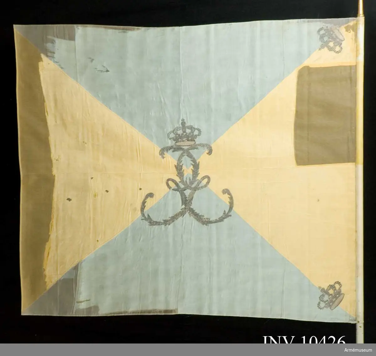Duk av taft, fyrstyckad, blå och gul. I mitten Gustaf III:s namnchiffer.