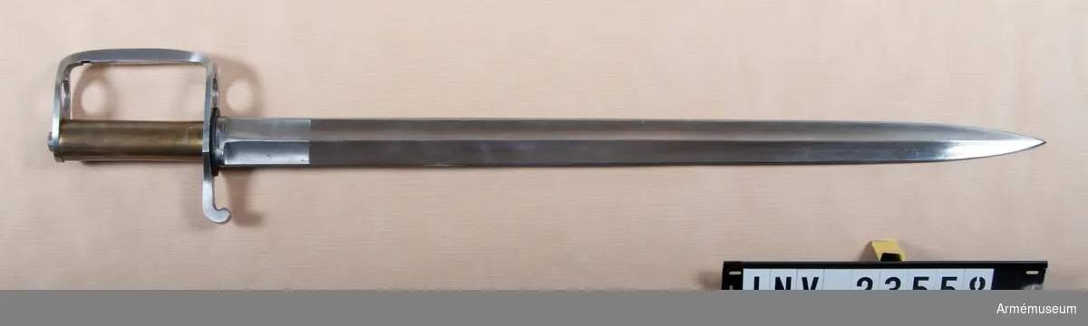 Grupp E II. 
Sabelbajonetten har 61,5 cm lång, upptill 3,8 cm bred, tveeggad med höga ryggar fördedd KLINGA, som ursprungligen tillhört en pallasch m/1773 eller -75. Klingan har upptill rester av en P-stämpel och upptill på insidan rest av en stor stämpel. Tydligen har klingan ingått bland de stora partier pallaschklingor, som 1774 och 1775 köptes till Sverige från Solingen (se von Schreeb, Gustavianska Pallascklingor, sidan 17 och 24). 

KAVEL av mässing, rak, slät med ovalt tvärsnitt. 
Parerstången är av järn har en bit framför kavelns bakre kant sin största bredd, 37 mm, och avsmalnar långsamt framåt, så att att den vid övergången till handbygeln är 31 mm bred. Bakåt avsmalnar den tvärt och är längst bak svängd nedåt samt litet framåt. 
HANDBYGELN är rätt tjock och utgår från parerplåten nära nog i rät vinkel. Upptill böjes den nästan i rät vinkel samt blir plötsligt bredare. 
Detta parerplåtens övre, bredare parti är närmast ovalt med största bredd av 33 mm. Tångänden är ej nitad utan i stället gängad och fasthålles av en ovanpå handbygelns övre sida liggande mutter. Framför kaveln genombrytes parerstången samt handbygeln bredare, övre parti övre parti av ett hål för pipan. Framtill  i detta hål finns en urtagning för bajonettklacken.  Längs handbygelns baksida går baksida går en kraftig fjäder, vars övre ände dels är inlaxad i handbygelns insida strax nedanför övre kröken och dels fast hålles med en skruv. Fjädern går något nedanför handbygelns mitt plötsligt bredare på yttersidan och bildar där ett sorts handtag eller tumtryck. Fjädern slutar strax ovanför parerstången med en bakåtvänd,  över spåret för bajonettklacken utskjutande klack. 

När man sätter på bajonetten trycker man spärrfjädern framåt och för in pipan i de därtill avsedda hålen. Fjäderns klack lägger sig redan nedanför nedre änden på pipans bajonettklack samt fast- låser sålunda bajonetten. 
J Alm 1940.