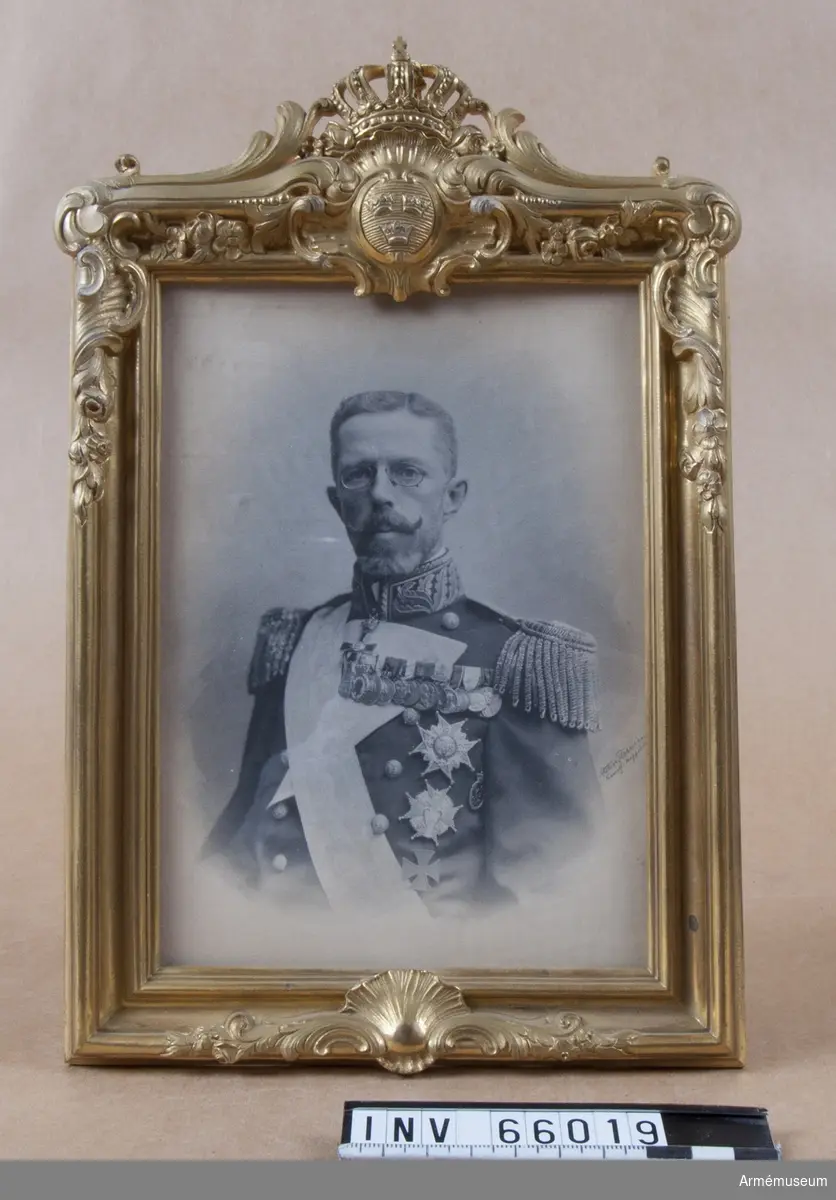 Grupp M I.
Fotografi av kung Gustav V med samhörande krönt ram.
