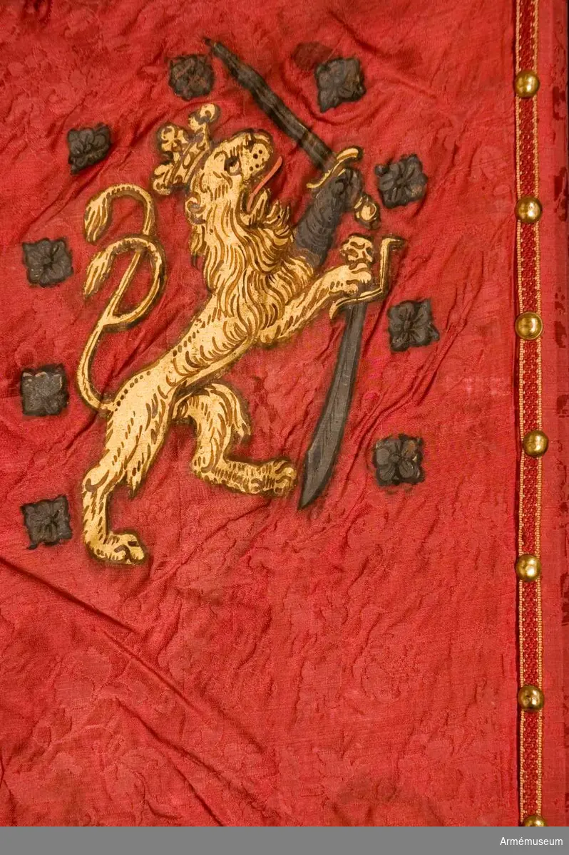Duk: Tillverkad av enkel, röd sidendamast sammansydd av två våder. Duken fäst med tre rader tennlickor på ett gult och rött mönstervävt band.

Dekor: Målat omvänt lika på båda sidor i övre, inre hörnet Stor-Finlands vapen, ett mot stången vänt dubbelsvansat lejon förande med vänster framfot en sabel under sig och med höger, som är harneskklädd, ett upplyft svärd, båda med klingor i silver och fästen i guld, åtföljt av nio silverrosor.

Frans: Dubbel, av rött silke. 

Stång: Tillverkad av trä, kannelerad. Löpande bärring.