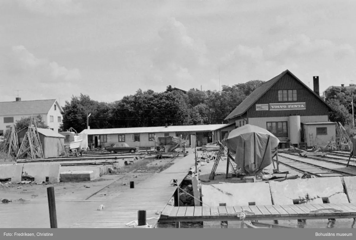 Motivbeskrivning: "Stenungsunds Båtvarv, till höger båtbyggarverkstaden, strax vänster därom f.d garage som numera används som försäljningslokal. Bilden tagen från bryggan."
Datum: 1980-07-15
Riktning: Ö