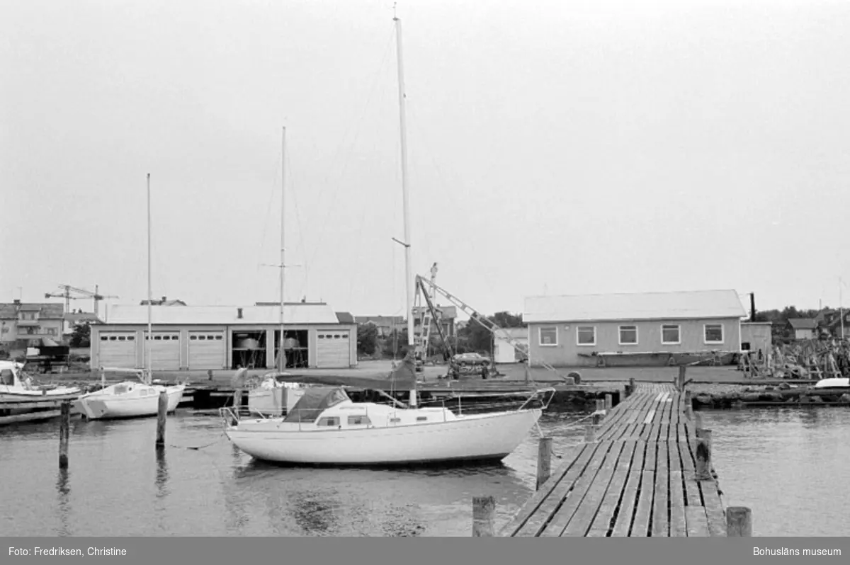Motivbeskrivning: "Amigo varvet, Öckerö. På bilden syns till höger byggnad inköpt av Arne Arksund år 1966 (byggnaden arrenderades från 1962), till vänster i bild den senaste tillbyggnaden på varvet (se Bb 18:29)."
Datum: 19800902
Riktning: Sv