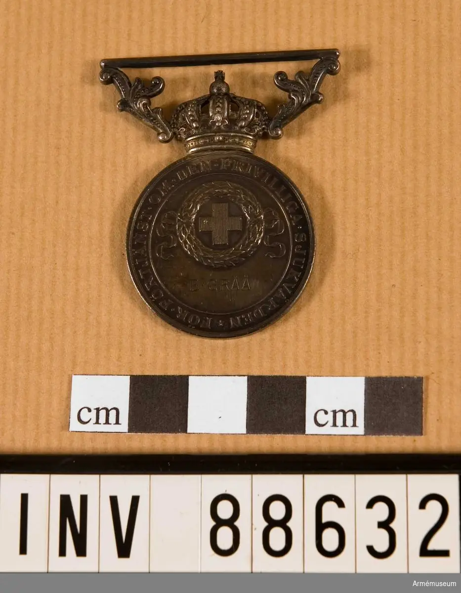 Förtjänstecknet tilldelat E. Gråå. Medaljen låg i käppi AM 88628. 