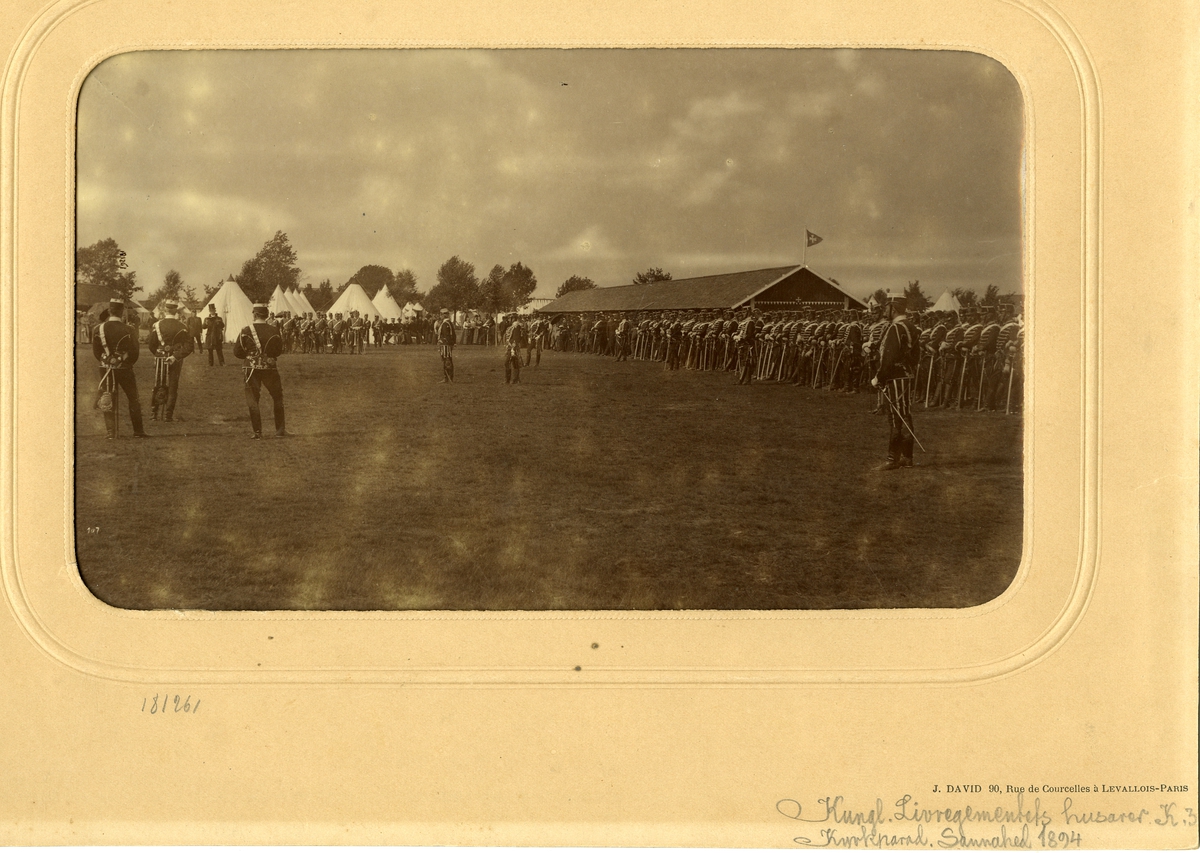 Livregementets husarer K 3 uppställda under kyrkparad i Sanna hed år 1894. I bakgrunden finns ett tältläger och civila åskådare.