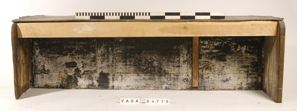 Bänkpanel till en kistbänk från kajutan. Panelen utgör hela bänkfronten och består av ett ramverk samt tre spegelfyllningar med profilerade lister runt om.