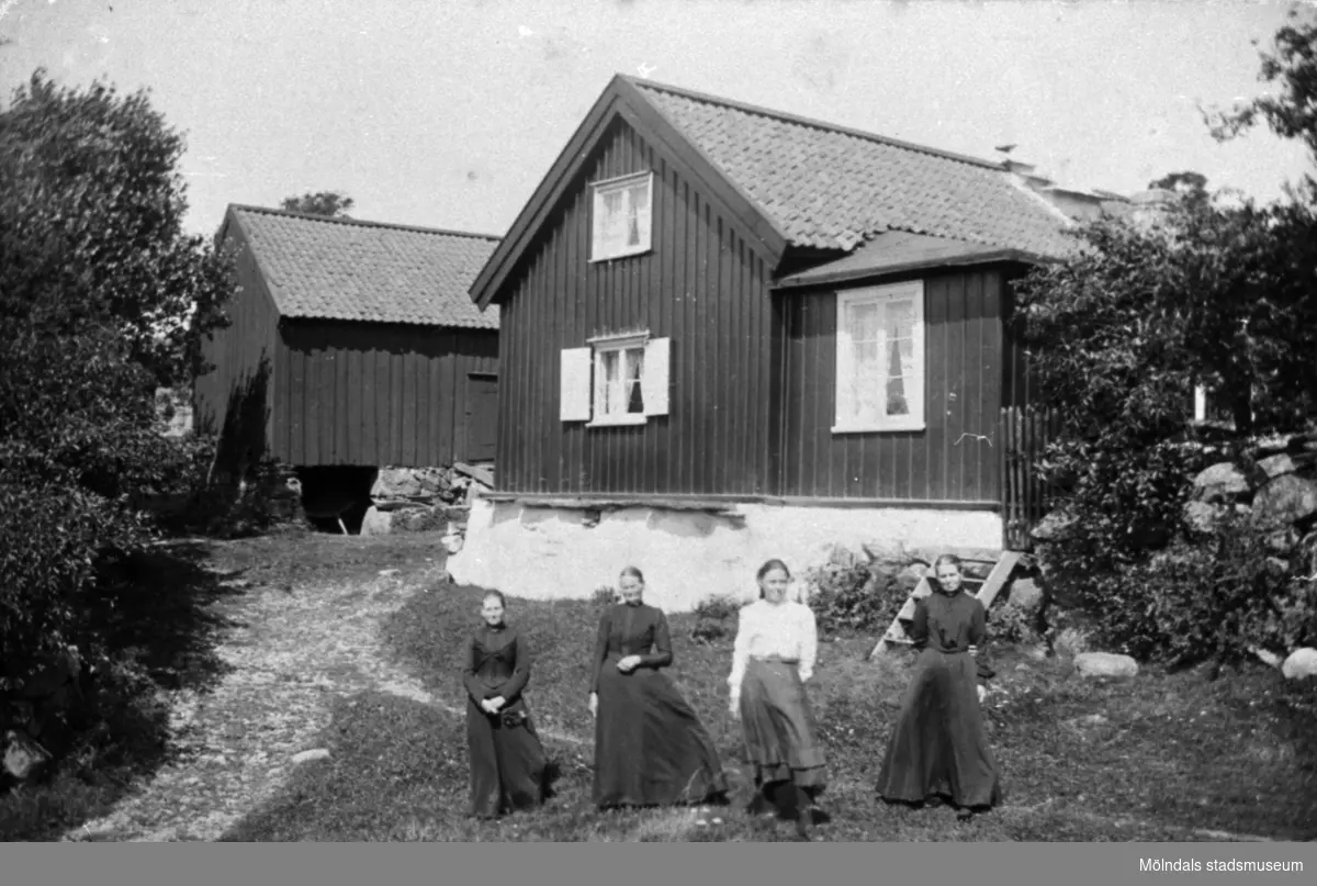 Från vänster står Anna Carlsson (1872-1955), Maria Eriksson (1840-1925), Valdeborg Johansson (1891-1970) och Josefina Eriksson (1856-1928) framför Olas stuga 1910-tal. Anna arbetade som piga i stugan.
Text på baksidan av fotot: "Ola stuga" Vommedal Östergård.
(Maria är syster till Josefina och moster till Valdeborg).