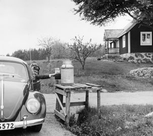Bilkåkande lantbrevbäraren Cyril Falk på linjen Lönsboda-Hunshult-Björkhult-Lönsboda. Brevlåda i Hunshult får post.

Foto maj 1961.