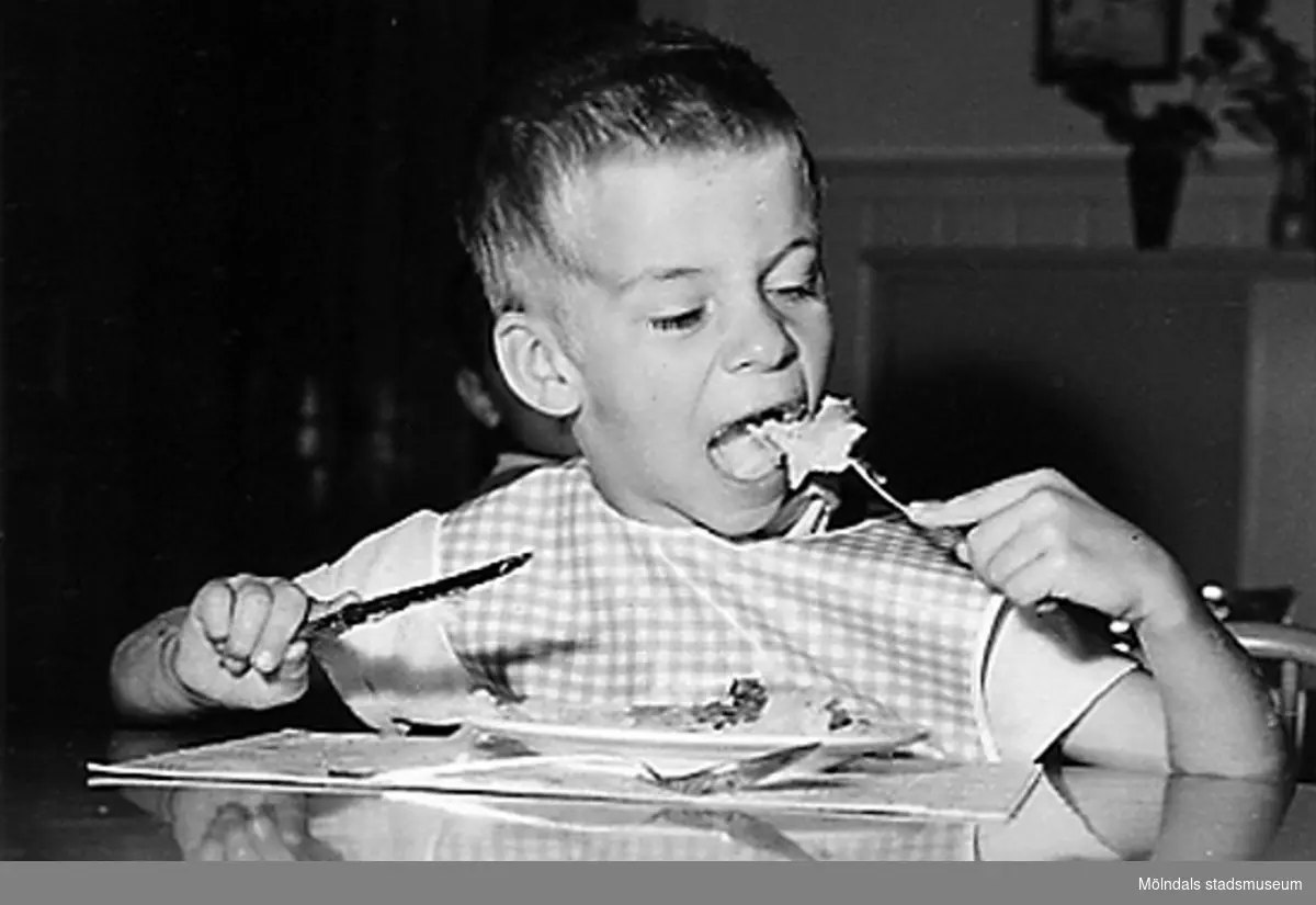 En pojke som sitter och äter. Holtermanska daghemmet 1953.