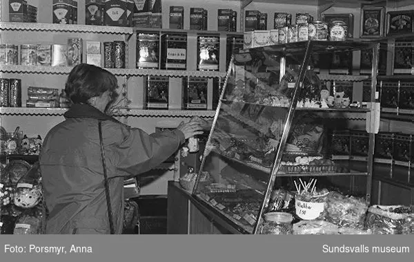 Kaffeaffären IDO, Nybrogatan. Bildsvit gjord för dokumentation utförd 1996. Affärsrörelsen grundades av Carl Dahlström den 18 november 1931. Dahlström föddes i Närsta, Alnö. Han arbetade som kassör på Hörningsholms sågverk 1918 till 1930 då sågen lades ner. Han fick inspirartion att starta kaffehandeln av sin bror Erland som arbetade på Kolonialvaruaktiebolaget. Mellan 1931 till 1937 drev Dahlström kaffehandeln tills en anställd, Eva Farm, tog över som nästa ägare. Sune Bäckström som tidigare arbetat som springpojke på firman tog över verksamheten 1954. Rosteriet som tidigare låg i magasinskvarteren (nuvarande Kulturmagasinet) flyttades 1983 till innergården vid Blombergska huset och en specialbyggd skorsten fick uppföras. Tonvikten på försäljningen ligger numera (2020) på ett välsorterat utbud av olika tesorter.