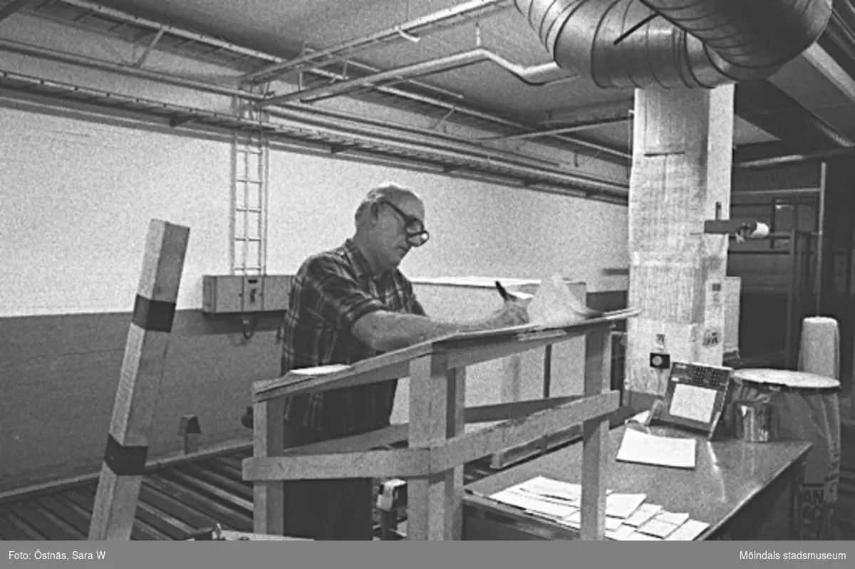 Gotthard Olsson utför kartongpallpackning på pappersfabriken Byggnad 6, 1980-tal. Bottenvåningen. Bilden ingår i serie från produktion och interiör på pappersindustrin Papyrus.