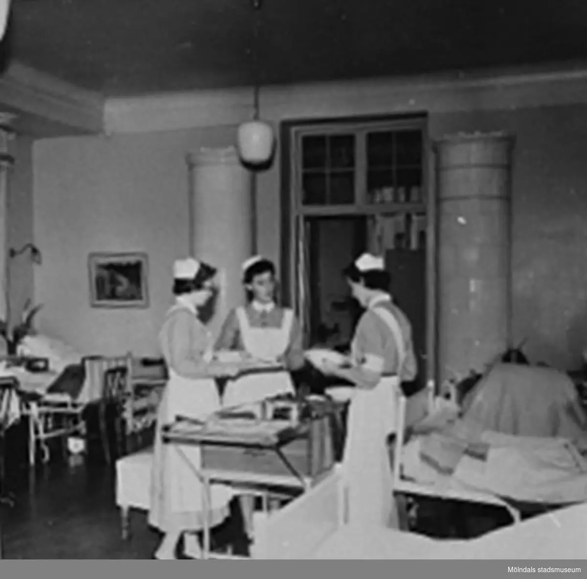 Tre sjuksköterskor delar ut mat på Sabbatsbergs sjukhus i Stockholm, 
cirka 1958. Alltid med nedkavlade ärmar.